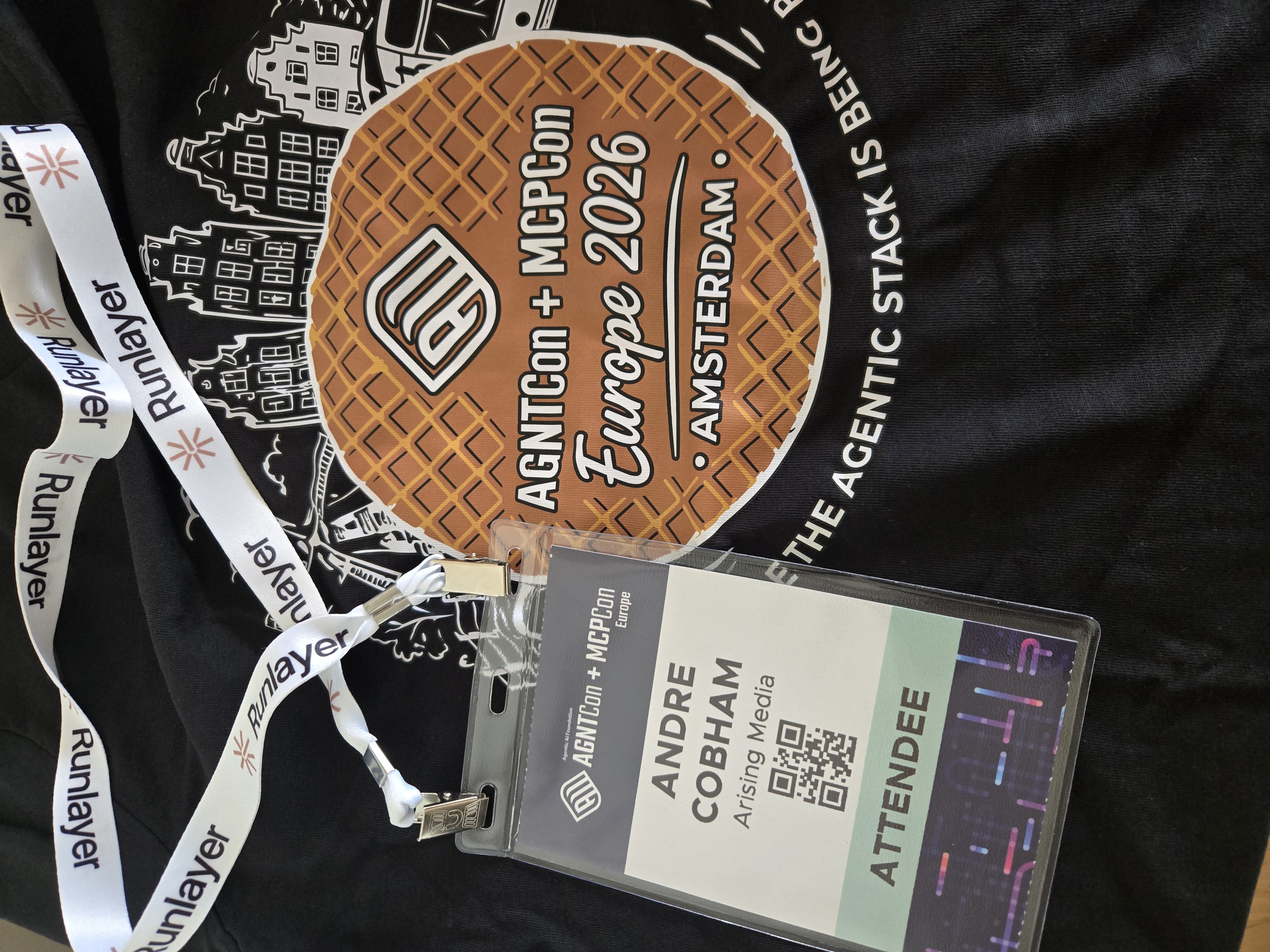 Andre Cobham's AGNTCon + MCPCon Europe 2026 attendee badge and stroopwafel-shaped event sticker from Amsterdam, by Andre Cobham