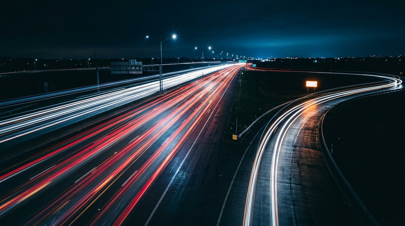 A long-exposure night photograph of a highway, most lanes a blur of red and white light trails continuing straight into the dark, one lane peeling off toward a brightly lit exit ramp, representing web traffic that never converts versus the smaller stream that actually reaches its destination, by Andre Cobham